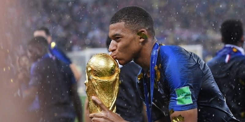 Hình ảnh chiếc cúp vàng World Cup lấp lánh dưới ánh đèn sân vận động, biểu tượng của vinh quang tột đỉnh